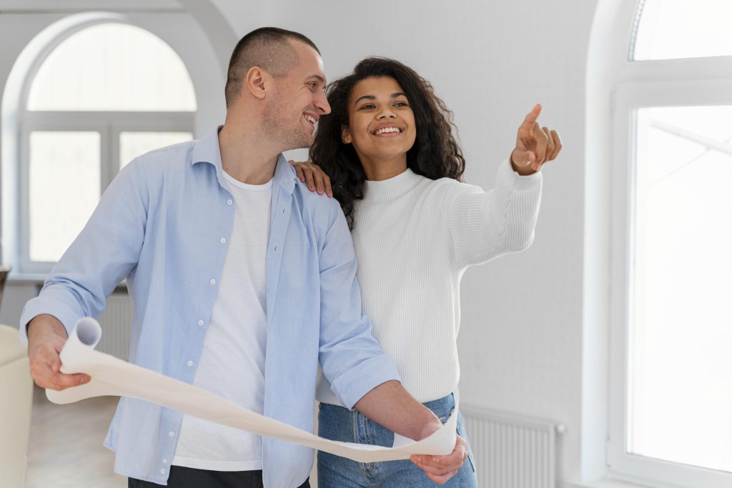 Couple souriant à l'intérieur de leur nouvelle maison après une courte séparation