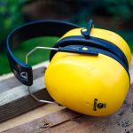 Écouteurs de protection jaune noir sur bois extérieur