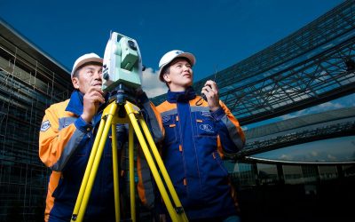 2 men in white hard hat holding a machine