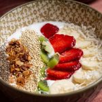 Assiette de yaourt garnie de fruits frais, granola et graines