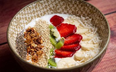 Assiette de yaourt garnie de fruits frais, granola et graines