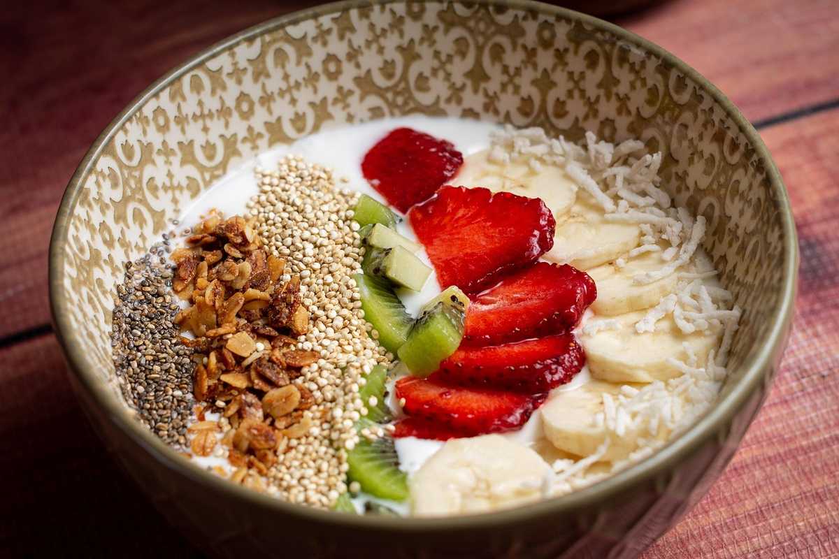 Assiette de yaourt garnie de fruits frais, granola et graines